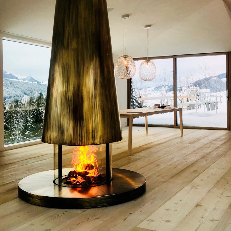 Freistehendes, massgefertigtes, rundes Cheminée in Messing von swissfirecube.