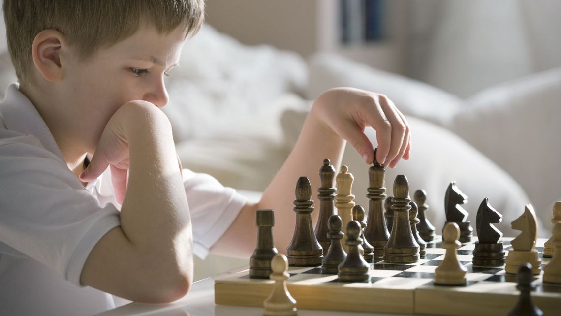Junge am Schach spielen