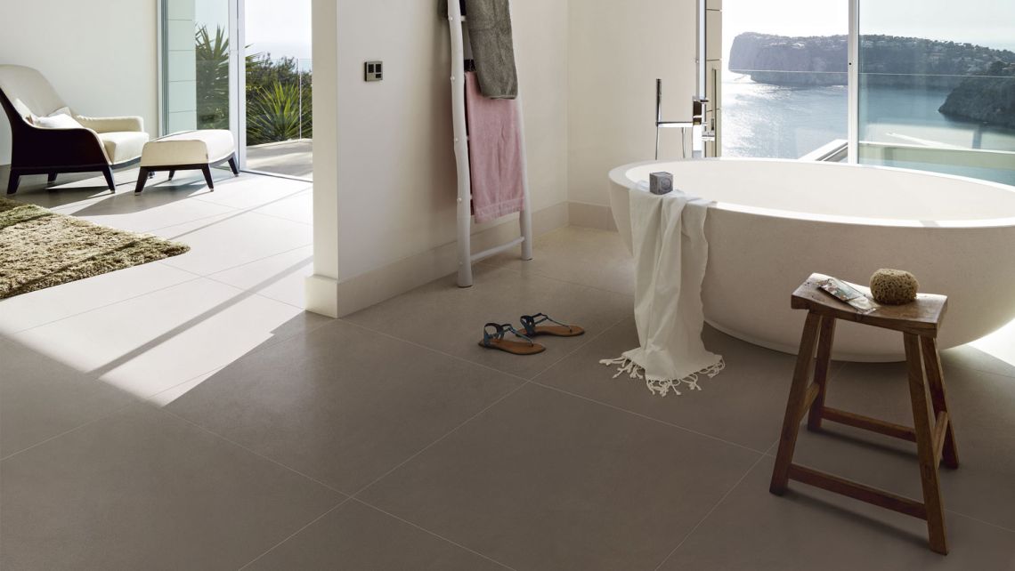 Beige, rechteckige und grossformatige Platten im Bad verlegt.